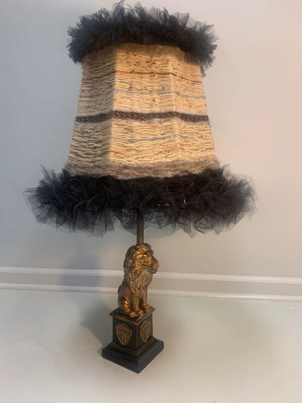 A lamp with a black fur and gold base.